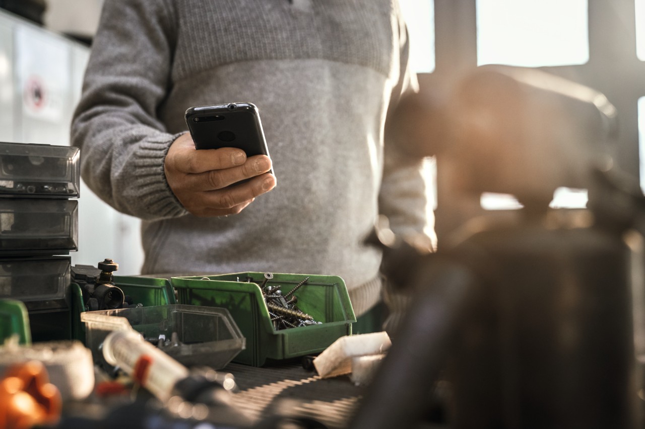 Person with smartphone in a garage