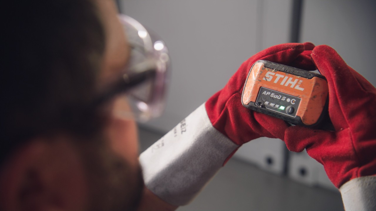A person holds a STIHL battery in his hands