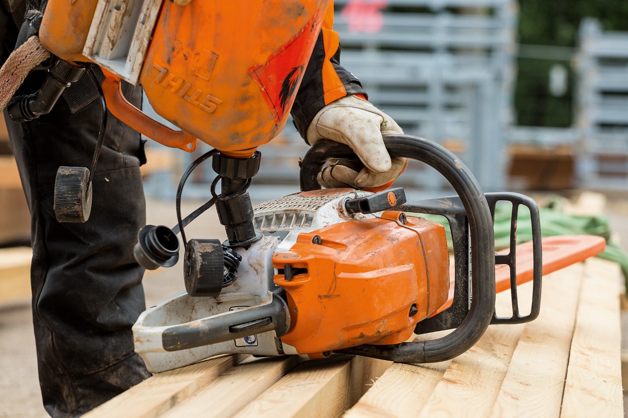The fuel tank of a STIHL chainsaw being topped up with fuel using the filling system.
